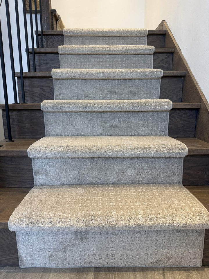 Light brown taupe stair runner on dark wood staircase with black spindles