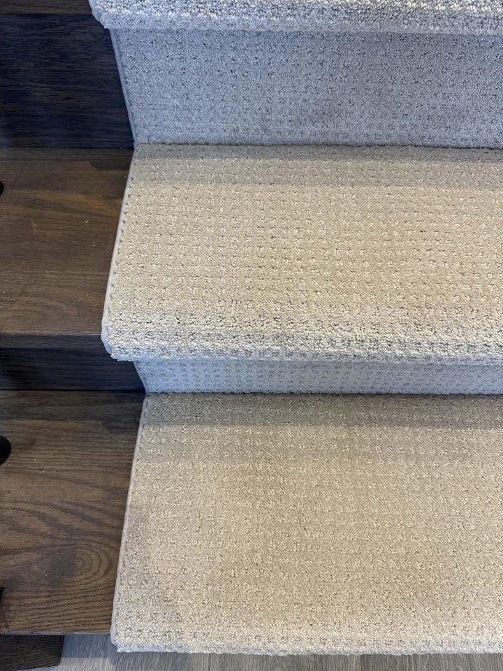 Close-up of Garibaldi Estate Democracy loop pattern stair runner carpet on dark stained stairs