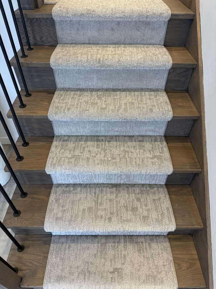 Modern linear pattern gray stair runner carpet on dark hardwood stairs