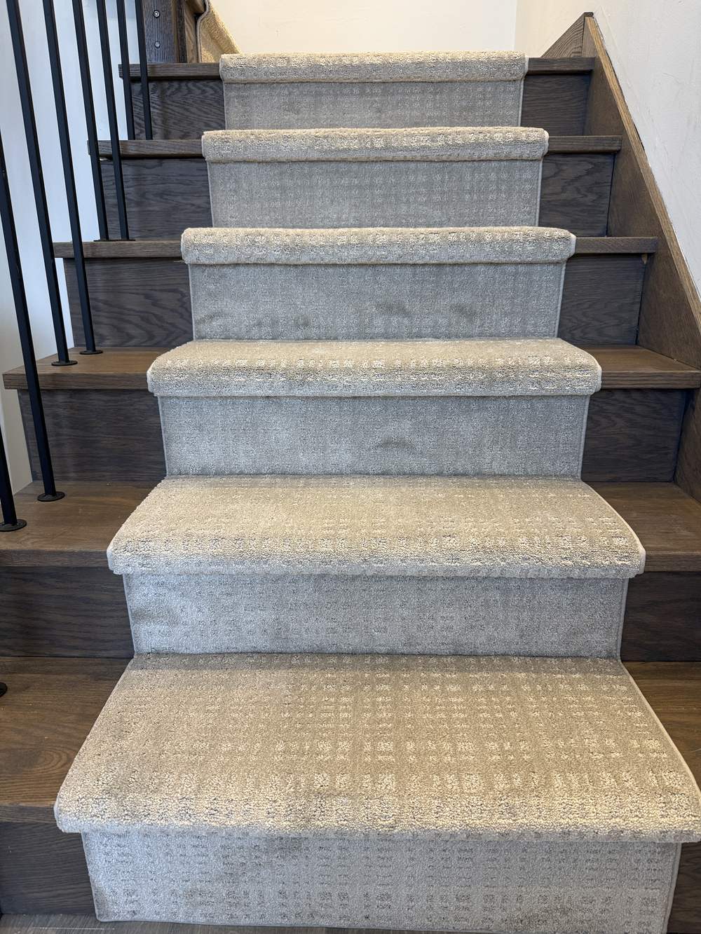 Modern pattern stair runner carpet on dark hardwood stairs