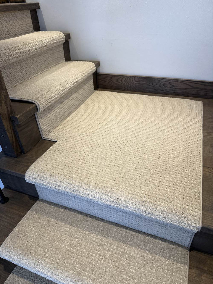 Stair runner with matching landing carpet on dark hardwood stairs