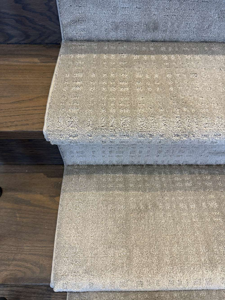 Close-up of Tanager Lodge Brown Bag stair runner carpet on dark stained stairs