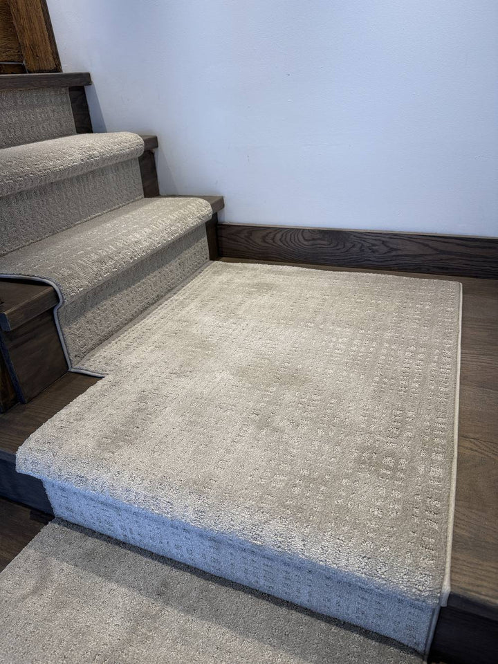 Stair runner with matching landing carpet on dark hardwood stairs