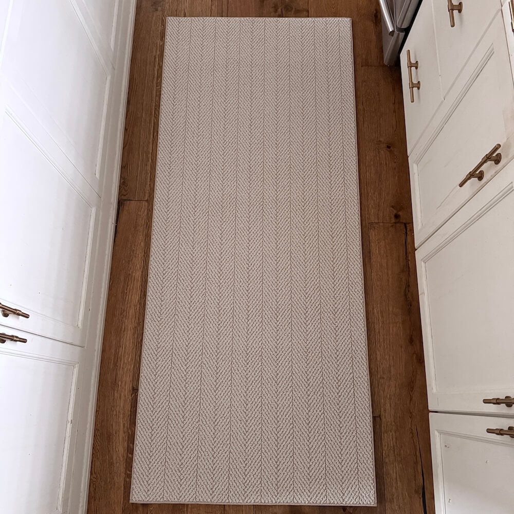 Beige patterned rug on a wooden floor in a kitchen setting