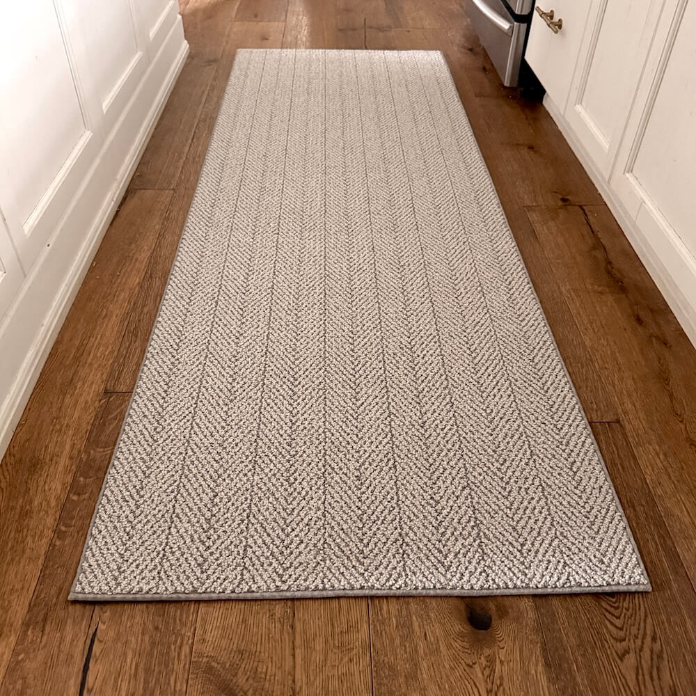 Gray textured rug on a wooden floor in a home setting