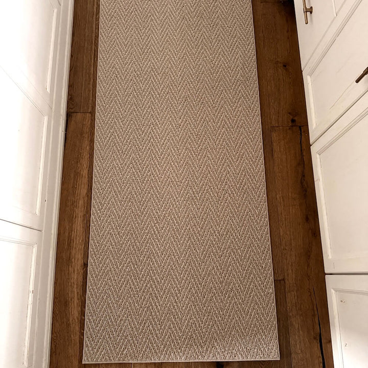 Patterned rug on a wooden floor with white walls and cabinets.
