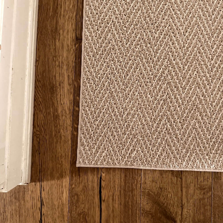 Beige textured rug on a wooden floor