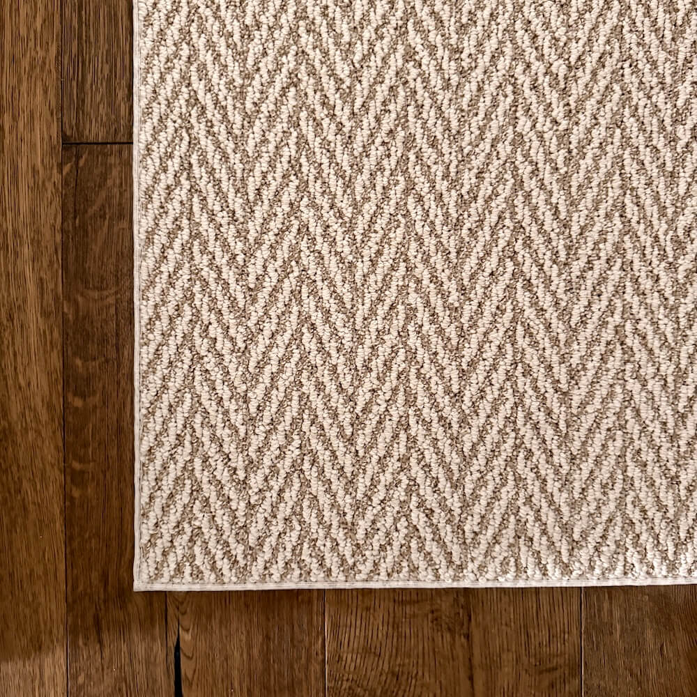 Beige textured rug on a wooden floor