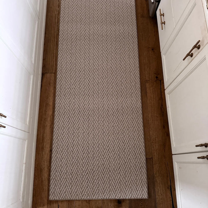 Patterned rug on a wooden floor with white cabinets on either side