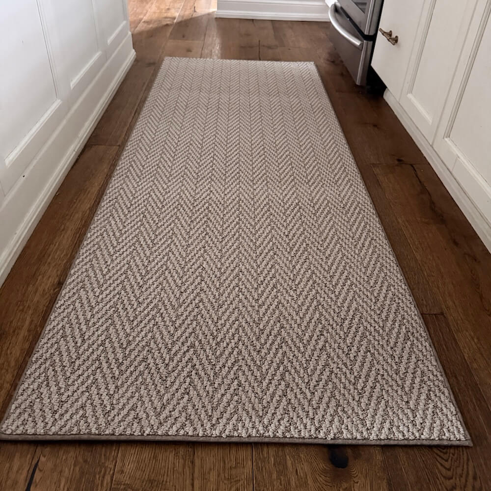 Herringbone patterned rug on a wooden floor in a kitchen setting