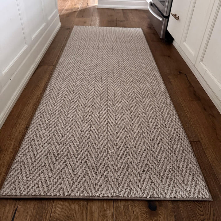Herringbone patterned rug on a wooden floor in a kitchen setting