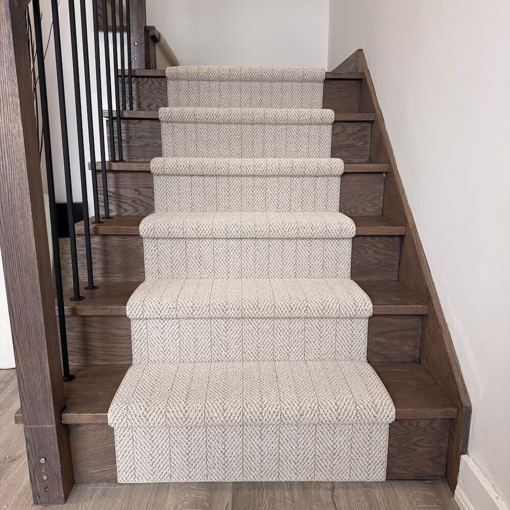 Wooden staircase with patterned carpet runner in a home setting