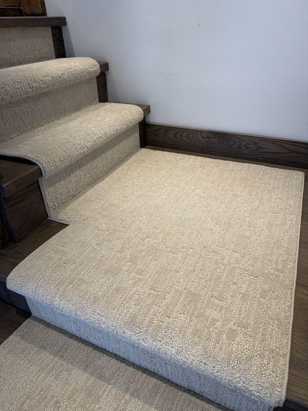 Stair runner with matching landing carpet on dark hardwood stairs