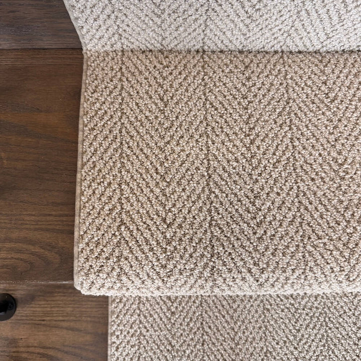 Close-up of textured beige carpet on a wooden floor
