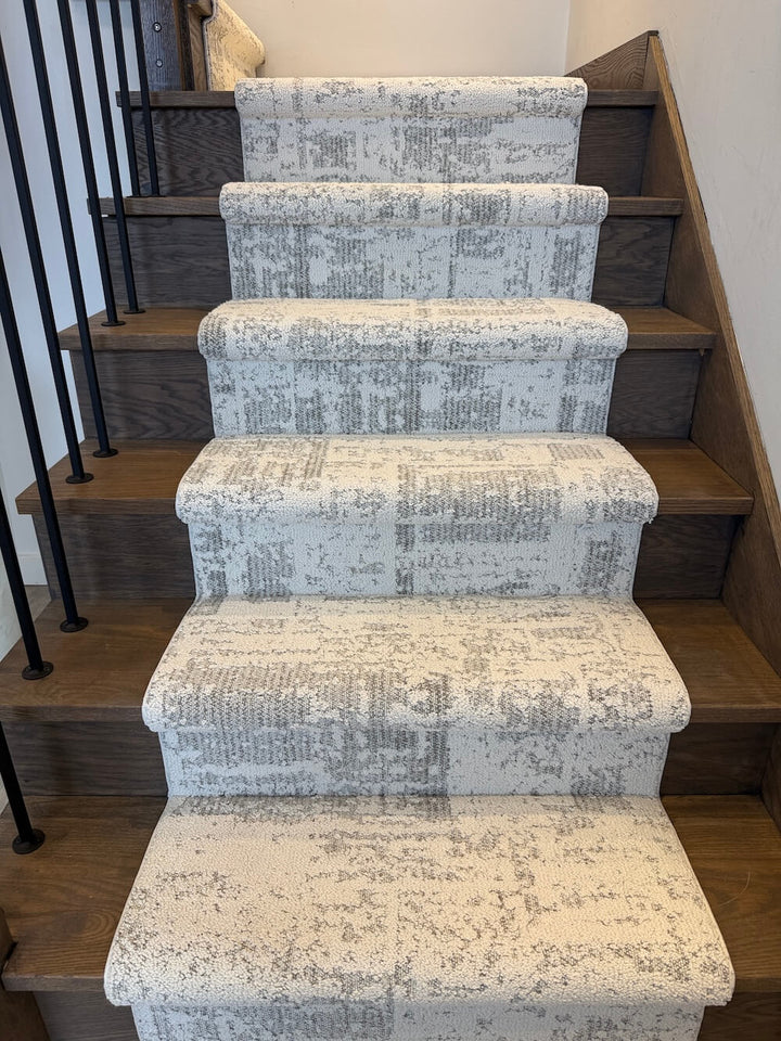Anderson Tuftex Discover First Frost stair runner on wooden stairs with a black metal railing