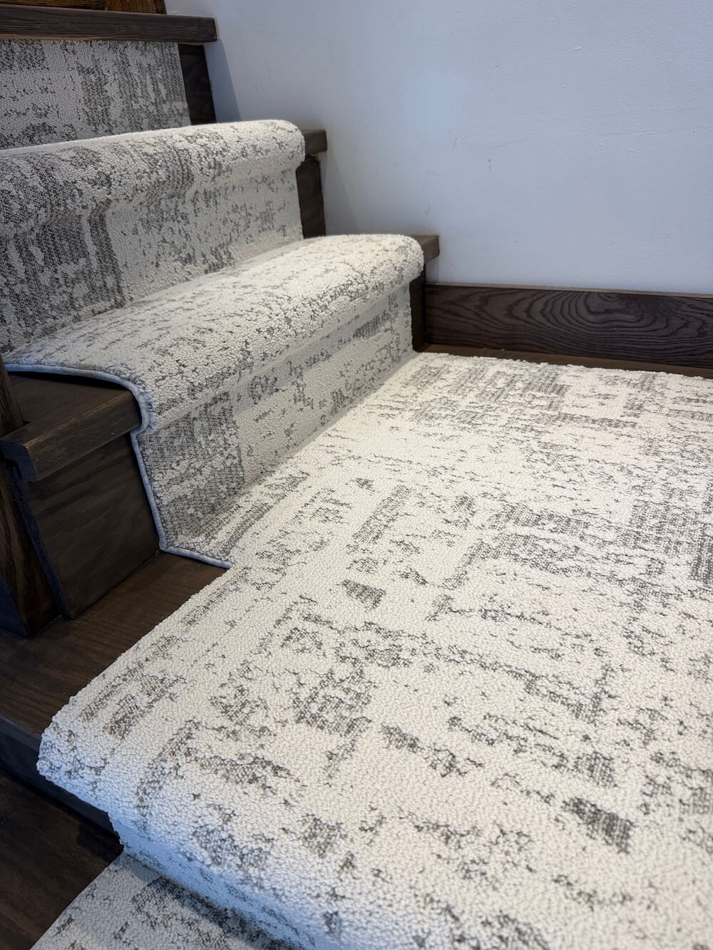 Discover First Frost stair runner landing in gray and off-white beside dark wood stairs