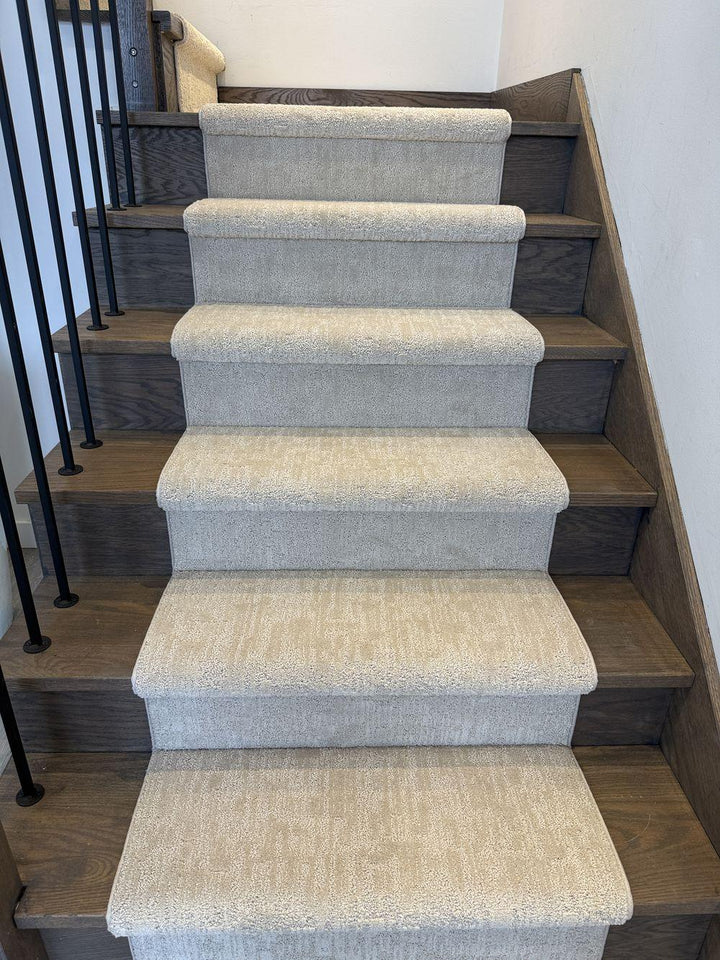 Beige gray stair runner on stained wood staircase with black spindles