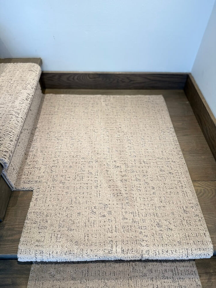 Beige textured stair runner rug on a wooden floor with a neutral wall background