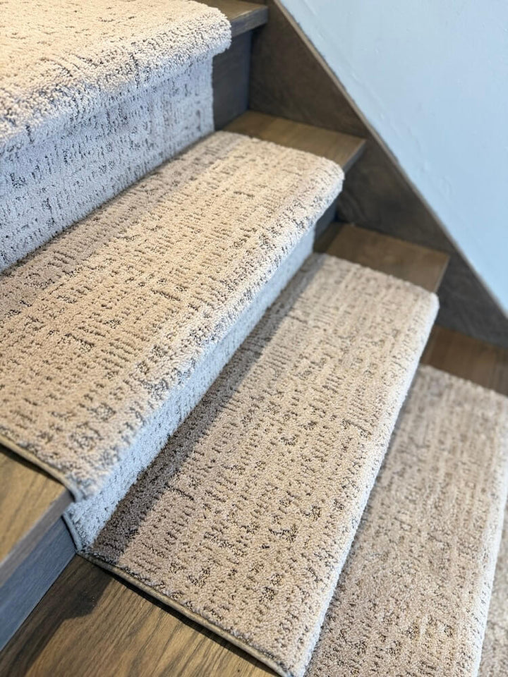 Staircase with carpeted steps in a neutral color scheme