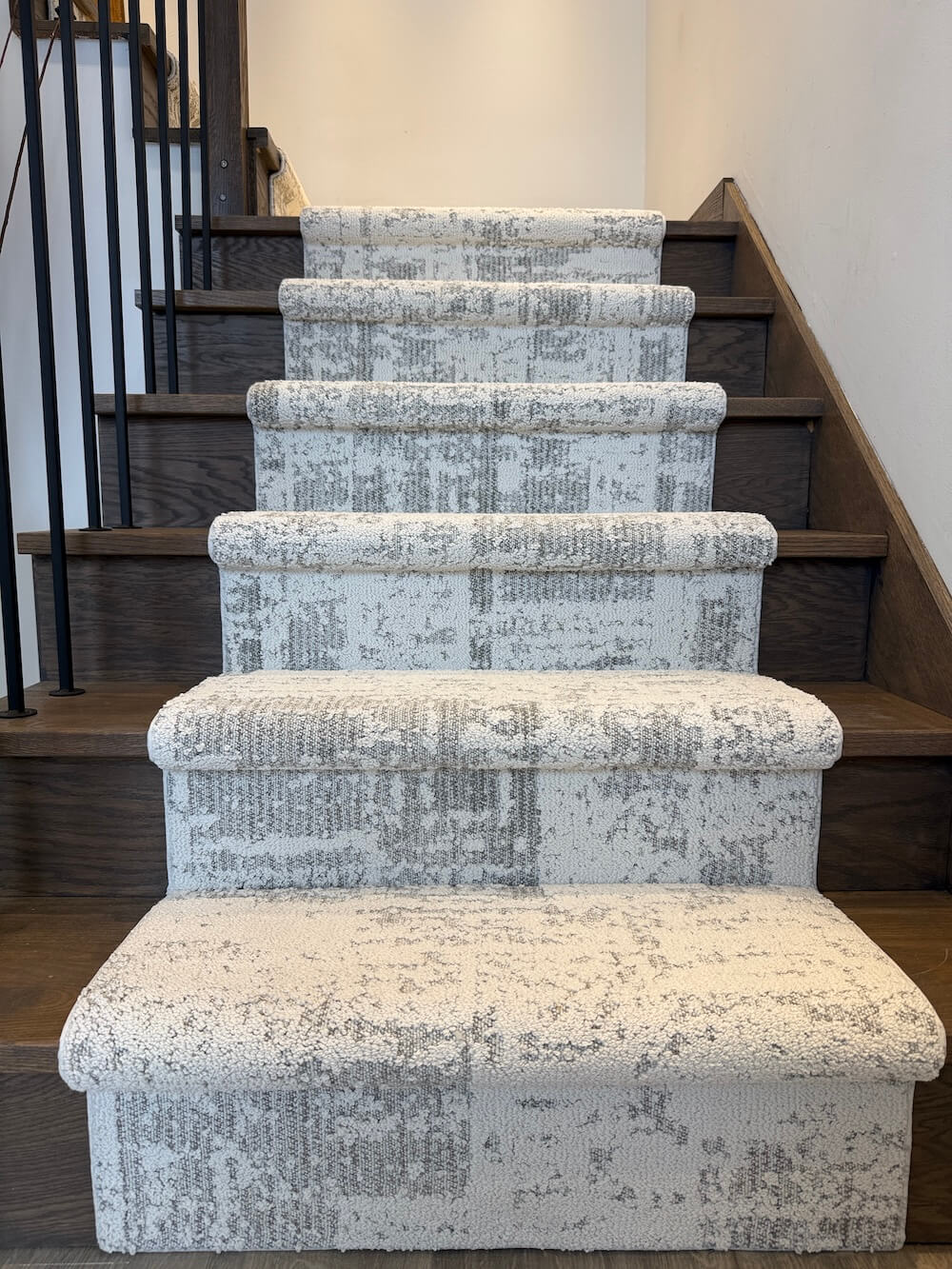 Anderson Tuftex Discover First Frost stair runner in gray and off-white on stairs with dark wood risers and a black metal railing