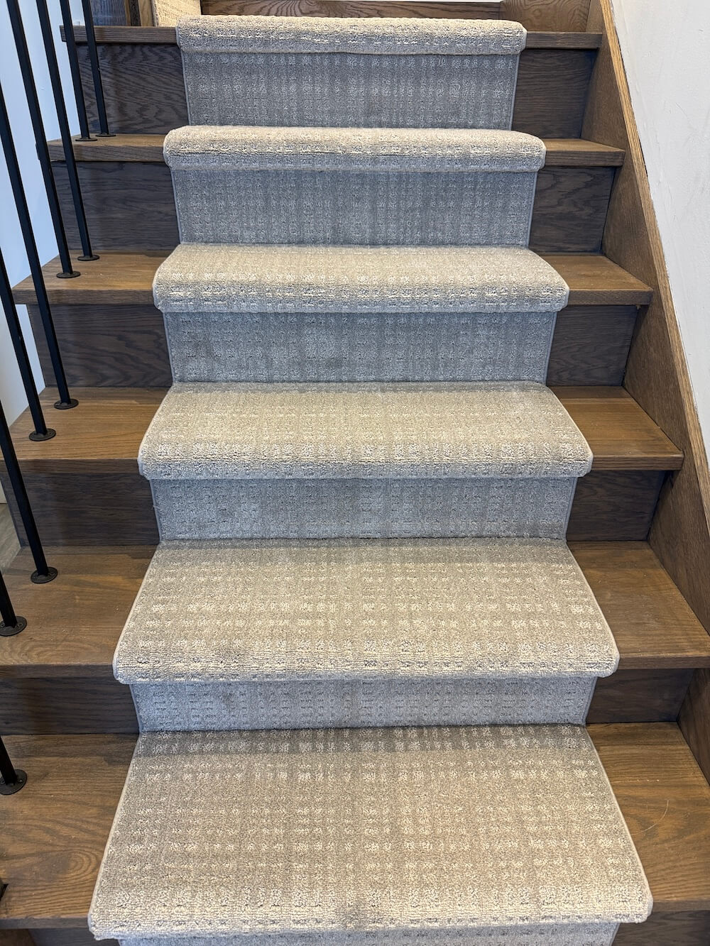 gray brown stair runner with pattern on wood stairs