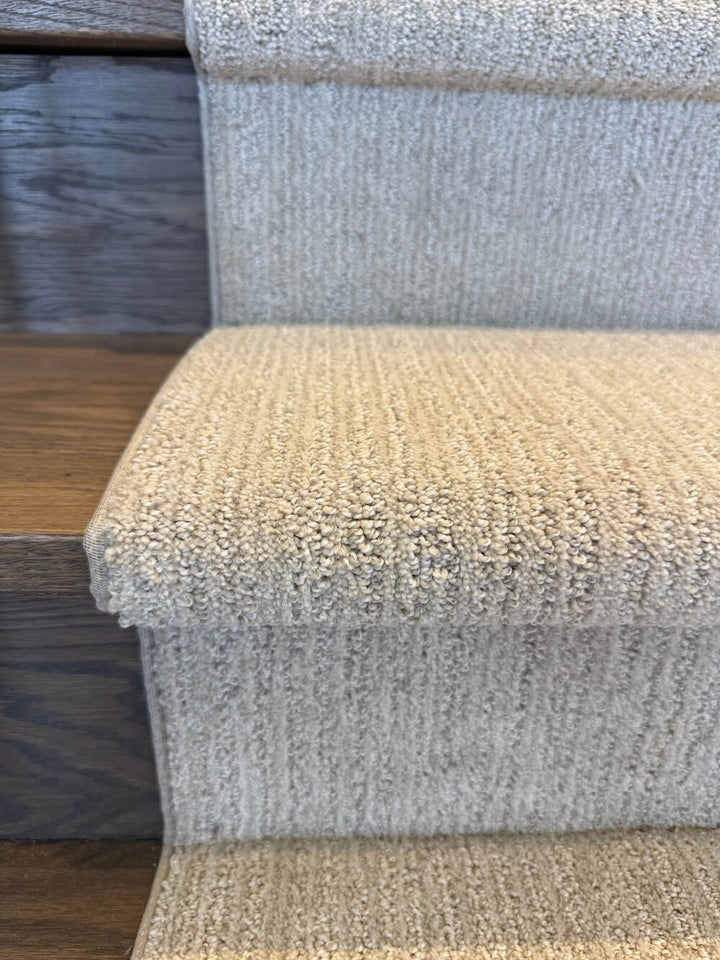 Beige stair runner wrapped over the stair bullnose