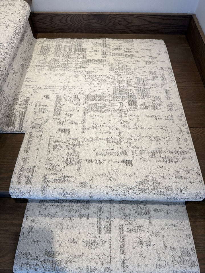 Anderson Tuftex Discover First Frost carpet in off-white and gray shown on a dark wood floor
