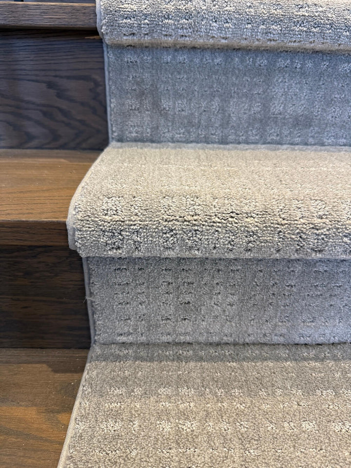 close up of gray stair runner on oak stairs