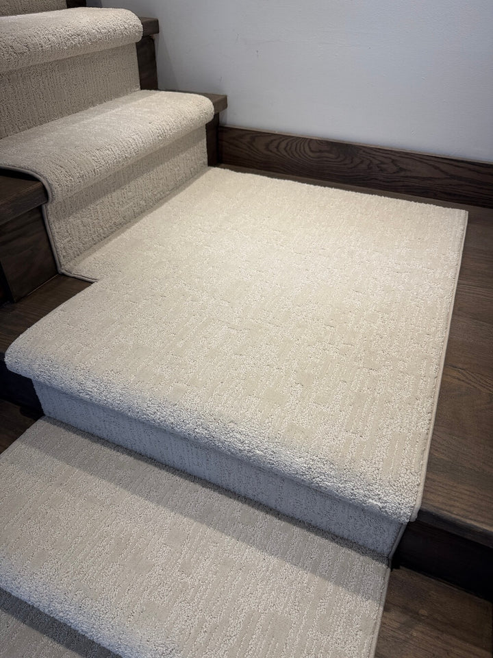 A set of light beige carpeted stair risers and steps installed on a wooden staircase indoors.
