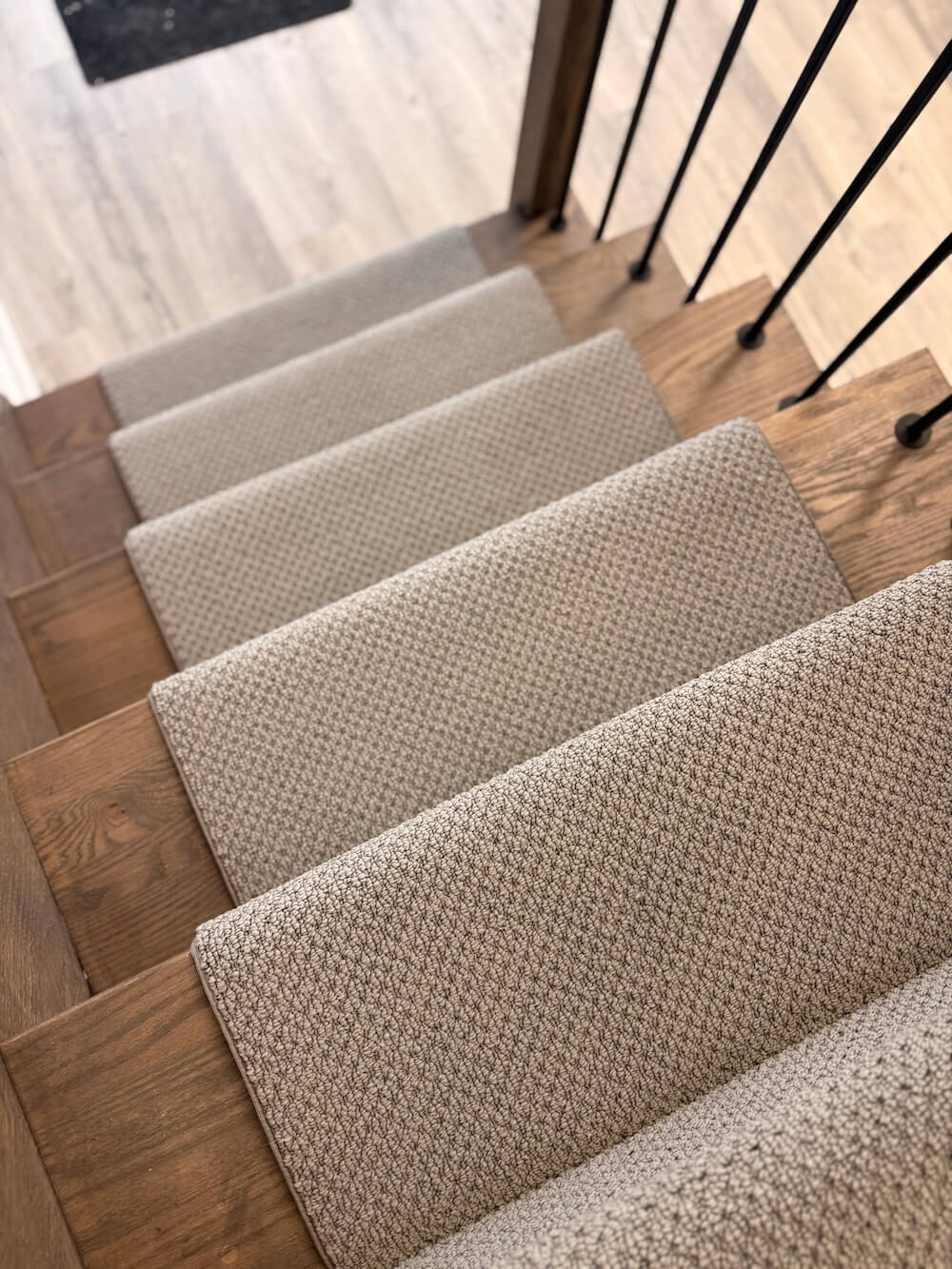 Staircase with gray carpeted steps and wooden treads