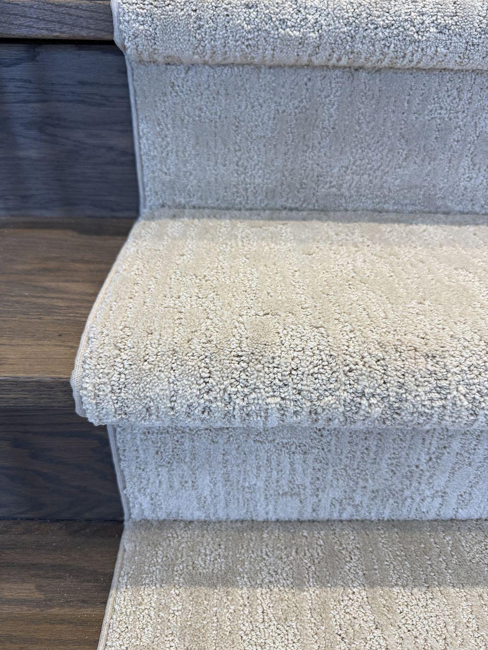 Top view of beige gray stair runner on wood stairs